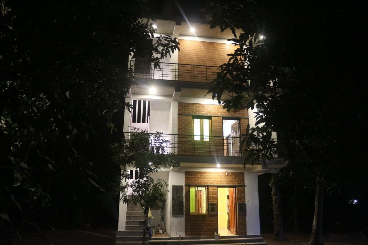 The multi-storey farmhouse lit up at night